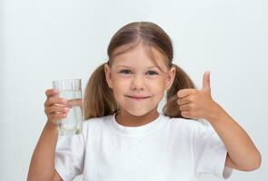 barn innehav glas av vatten på vit bakgrund foto