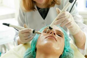 kosmetolog gör de procedur mikroström terapi skönhet salong foto