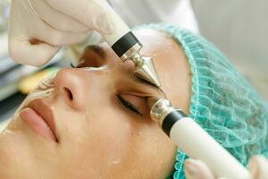 kosmetolog gör de procedur mikroström terapi skönhet salong foto
