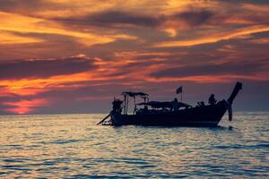 fiske båt med solnedgång i phi phi öar, thailand foto