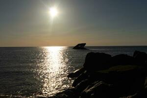 solnedgång strand i cape Maj ny jersey var du kan skaffa sig en bra se av de Sol gående ner tvärs över de hav och de bukt. de reflexion av de Sol på de vatten med de nedsänkt fartyg utseende så skön. foto