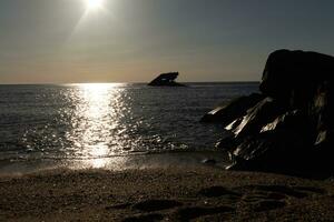 solnedgång strand i cape Maj ny jersey var du kan skaffa sig en bra se av de Sol gående ner tvärs över de hav och de bukt. de reflexion av de Sol på de vatten med de nedsänkt fartyg utseende så skön. foto