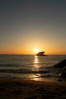 solnedgång strand i cape Maj ny jersey var du kan skaffa sig en bra se av de Sol gående ner tvärs över de hav och de bukt. de reflexion av de Sol på de vatten med de nedsänkt fartyg utseende så skön. foto