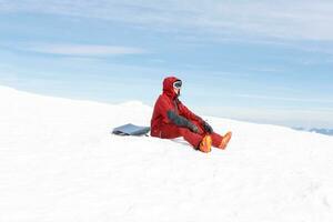 snowboardåkare sitter hög i de bergen foto