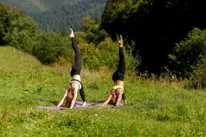 kondition kvinnor i triangel utgör medan praktiserande yoga på en parkera. foto