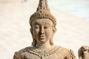 en staty av en buddha är stående på en sten foto