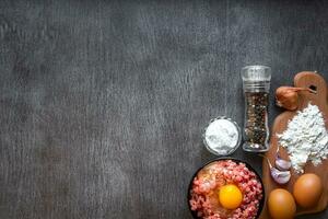 rå mald kött med ägg äggula, trä- skärande styrelse på trä- bakgrund foto