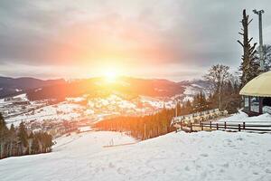 panorama av åka skidor tillflykt, backe, människor på de åka skidor hiss, skidåkare på de pist bland grön tall träd och snö lansar. foto