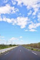 ett tömma motorväg med en blå himmel och moln foto