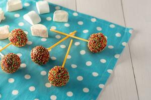 hemlagad mycket liten kakor - cakepops för barns födelsedag på en vit trä- bakgrund. foto