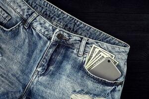 kontanter och smart i din jeans ficka. fortfarande liv. foto