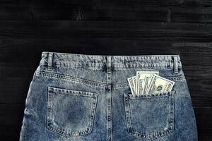 ficka pengar. dollar i höft ficka av bärs blå jeans. närbild. foto
