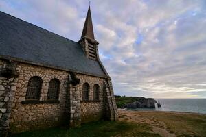 en kyrka på de kust med en se av de hav foto