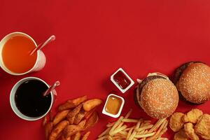 burger och pommes frites. hamburgare och franska frites i röd papper låda. snabb mat på röd bakgrund. foto