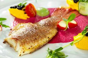 fisk maträtt - friterad fisk filea och grönsaker foto