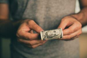en man innehar dollar i hans händer foto