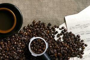 kaffe bönor, ark musik och kaffe kopp på en säckväv bakgrund foto