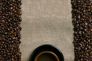 kaffe bönor och kaffe kopp på en säckväv bakgrund foto
