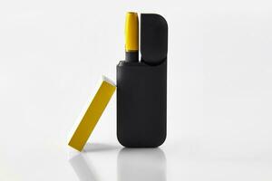 ny generation svart och gul elektronisk cigarett i öppen batteri och tändsticksask isolerat på vit. uppvärmning tobak systemet. reklam, stänga upp foto