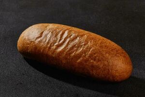 färsk, gott bakad bröd mot svart bakgrund med kopia Plats. lantlig kök eller bageri. närbild foto