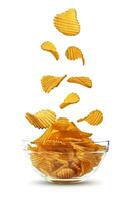 spårförsedd potatis chips faller ner i glas skål, isolerat på vit bakgrund med kopia Plats för text, bilder. Krispig pommes frites. reklam. närbild. foto