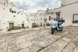 se av de gammal stad av martina franca. klassisk blå moped på de bakgrund av ett anient byggnader. foto