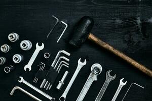 renovera en bil. en uppsättning av reparera verktyg- hex nycklar, en hammare och en skruvmejsel på en svart trä- bakgrund. stänga upp. topp se. foto