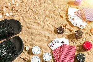 beachpoker. pommes frites och kort på de sand. runt om de snäckskal och flip floppar. topp se foto