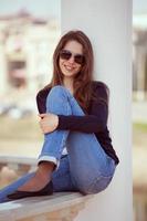 charmig kvinna i glasögon och blå jeans foto