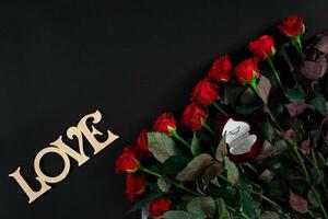 röd rosor, ringa och gåva låda på svart bakgrund foto