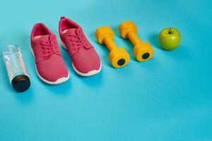 friska begrepp, diet planen med sport skor och flaska av vatten och hantlar på blå bakgrund, friska mat och övning begrepp foto