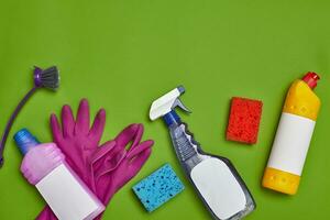 tvättmedel och rengöring Tillbehör på en grön bakgrund. hushållning begrepp. foto