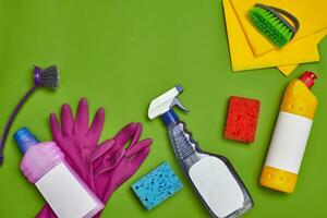 tvättmedel och rengöring Tillbehör på en grön bakgrund. hushållning begrepp. foto