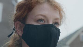 närbild av ung vit kvinna som står utanför och bär ansiktsmask foto