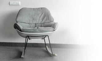 gungande stol mot de vägg. interiör inuti. selektiv fokus foto
