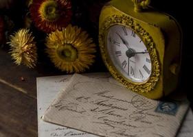 klocka med kuvert på ett gammalt träbord foto