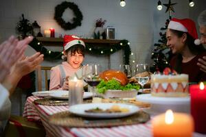 söt liten flicka i santa hatt öppning jul närvarande och leende. foto