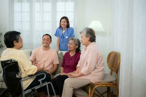 närbild av senior kvinna i rullstol med henne vårdgivare i bakgrund och äldre vänner är väntar till Välkommen foto