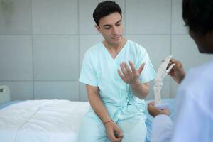 läkare som visar modell av finger ben till patient i sjukhus. medicinsk och sjukvård begrepp. foto