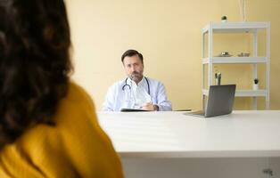 kvinna patient lyssnande till en manlig läkare på de skrivbord i de kontor av läkare foto