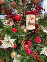 jul träd med röd och gyllene dekoration och en snögubbe leksak foto