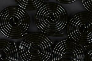 spiral svart bakgrund. lakrits godis i de form av en spiral närbild. foto