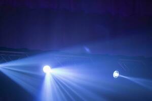 blå strålar av en skede strålkastare på en mörk bakgrund. foto