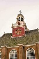 en klocka torn på topp av en byggnad med en röd tak foto