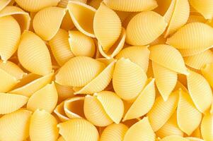 rå pasta conchiglioni spaghetti mönster. mat bakgrund, italiensk kök foto