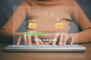 överföring av filer datasystem flyttkoncept, person hand som använder bärbar dator som väntar på överföringsfilprocessen med laddningsfältikonen på virtuell skärm. foto
