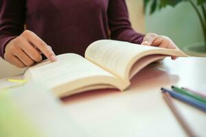 flicka studerande läsning bok framställning för högskola examen ung kvinna studerande studerar och skrivning på anteckningsbok framställning i skola bibliotek. foto