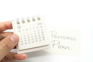 skrivbord kalender och pension planen notera papper isolerat på vit bakgrund. för pensionering, pension planen begrepp. sista datum av arbete. foto