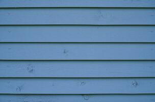 blå trä bakgrund. de vägg av de hus tillverkad av blå trä- brädor. foto