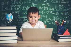 barn använder dator laptop i klassrummet. foto